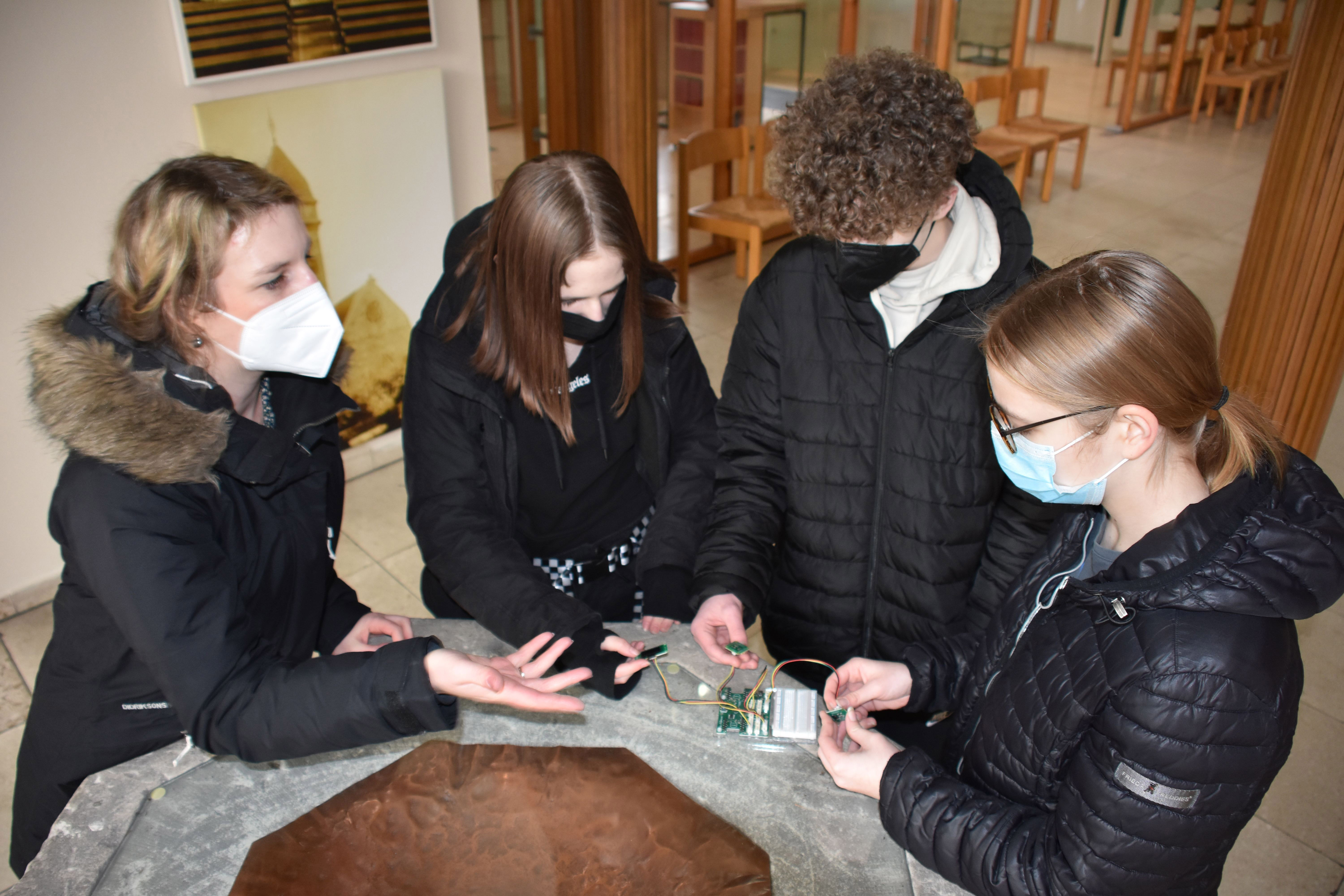Lehrerin Annette Kakoschke mit Schülergruppe bei Messungen am Taufstein. Foto: Carl-Friedrich-Gauß-Gymnasium Gelsenkirchen