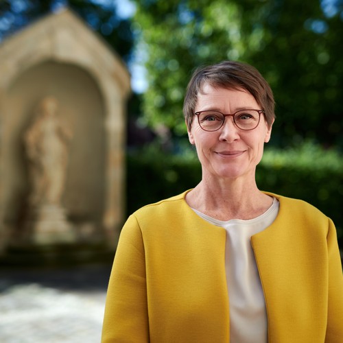 LWL-Expertin vor einer Sandsteinfigur