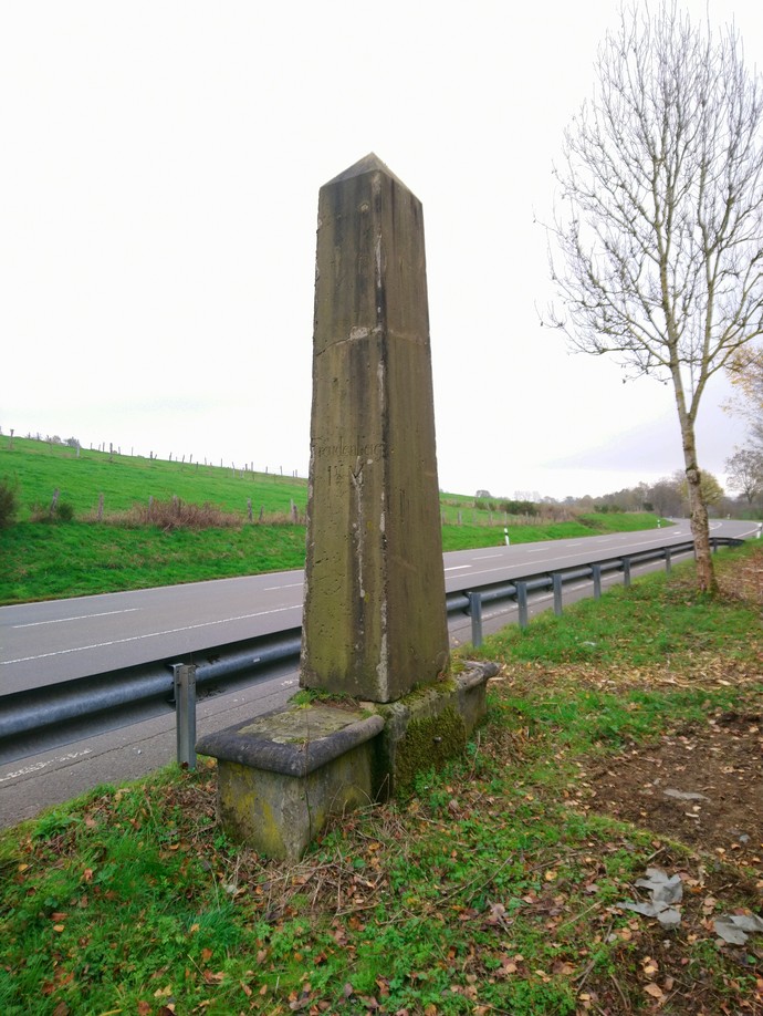 Vollmeilenstein aus Obelisk und Podest mit Sitzbänken, Gemeindegebiet Wenden, südwestlich von Ottfingen, Kreuzung L 512 und Straße nach Römershagen