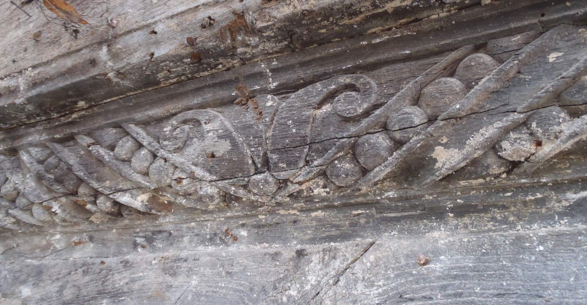 Detail eines Füllholzes mit Perlstabfries und Blütendekor.