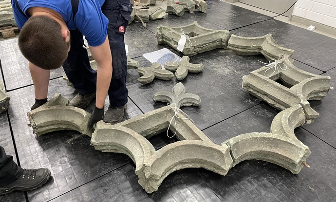 Beim Zusammensetzen der gotischen Fensterrosette aus dem Kloster Wedinghausen – ein Exponat der Ausstellung