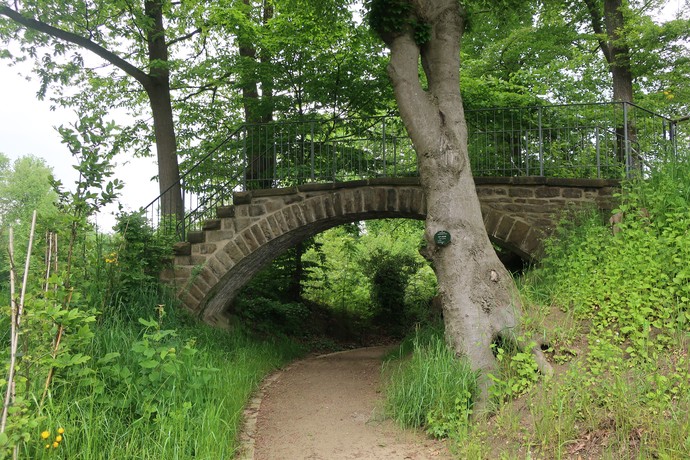 Der untere Teil des Schneckenweges führt unter einer massiven Natursteinbrücke hindurch