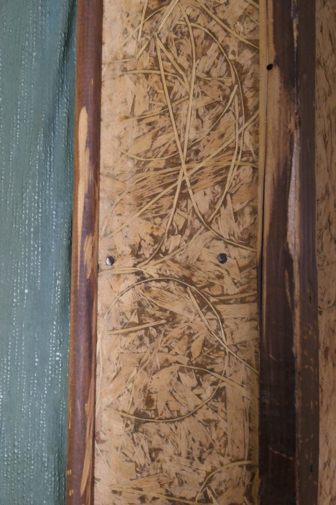 Detail der „Holzvertäfelungen“ aus Spanplatten mit der besonderen Textur und den mit Schellack lackierten Zierleisten