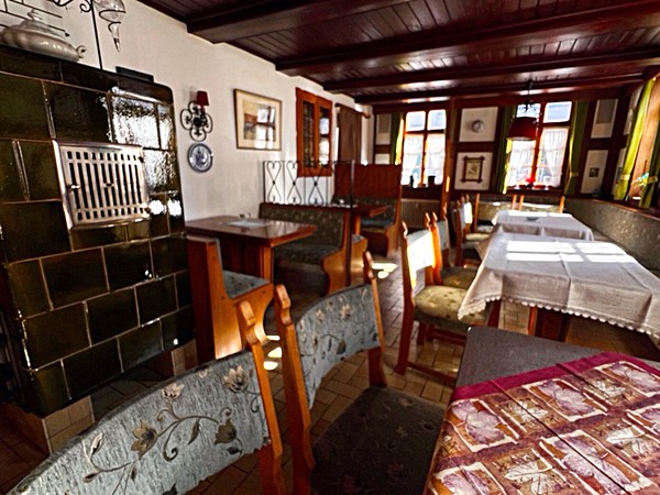Gastraum mit Kachelofen – ehemaliges Restaurant im Erdgeschoss