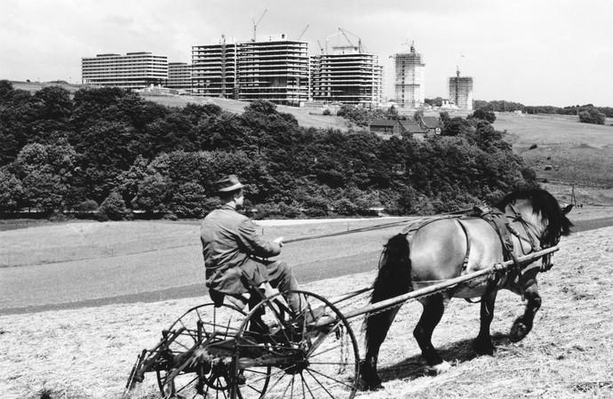 Neubau der Ruhruniversität im ländlich geprägten Stadtteil Querenburg. Im Vordergrund ist ein Pflug mit Pferd zu sehen.