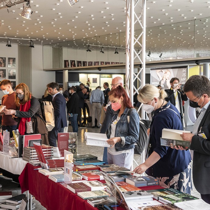 Am Büchertisch (vergrößerte Bildansicht wird geöffnet)