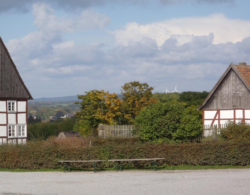 Blick über historische Fachwerkgebäude auf Windräder im Hintergrund