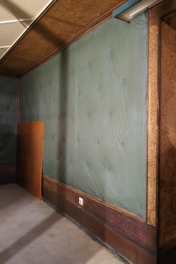 Polsterungen an den Wänden im Kinosaal, die stark verdreckt sind sowie Wand- und Deckenverkleidungen mit Faserplatten