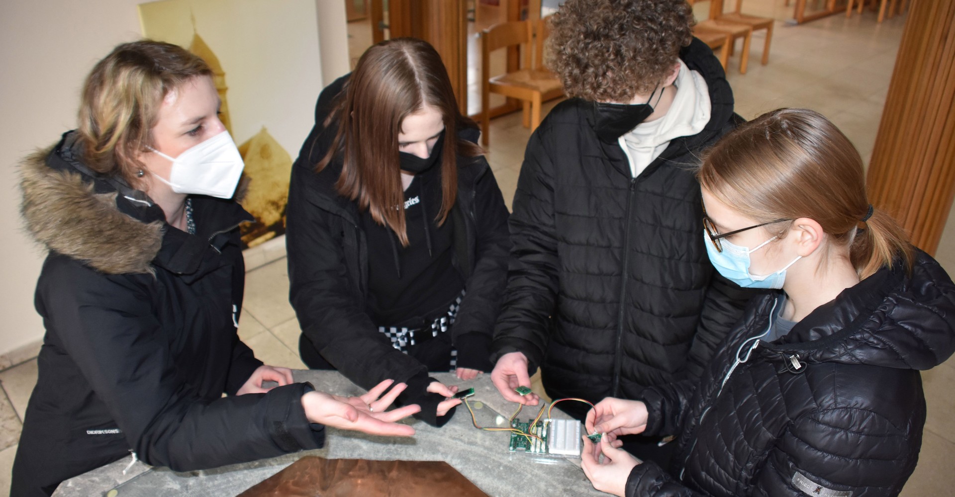 Lehrerin Annette Kakoschke mit Schülergruppe bei Messungen am Taufstein. Foto: Carl-Friedrich-Gauß-Gymnasium Gelsenkirchen