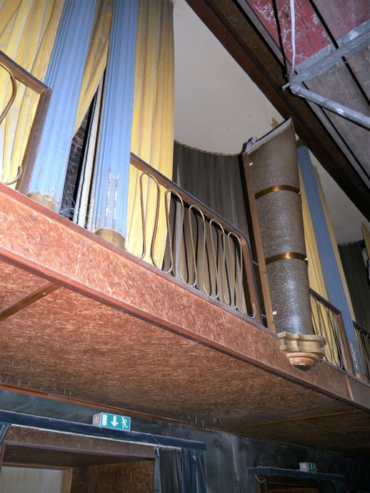 Tütenlampe, blaue kannelierte Säulen und gelbe Samtvorhänge an den Logenattrappen sowie „Holzvertäfelungen“ aus Spanholzplatten (vergrößerte Bildansicht wird geöffnet)